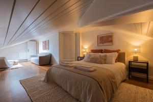 a bedroom with a large bed and a living room at Windmill Beachfront Villa in Colares