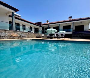 a large swimming pool in front of a building at Quinta do Portal Guest House in Bespeira