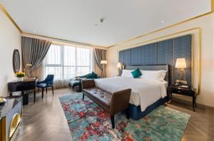a hotel room with a large bed and a desk at Dolce by Wyndham Hanoi Golden Lake in Hanoi