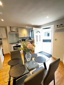 a kitchen with a table with chairs and a vase of flowers at 2 Southwell Road - Luxurious City Centre Apartments in Norwich