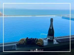 een fles champagne en een schaal fruit en een fles wijn bij Luxury Rooftop Suites by Blumont in Durrës