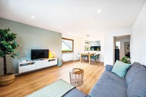 a living room with a blue couch and a tv at Casa Tortuga - Ruhige 3 Zimmer Wohnung in Hüttenfeld in Lampertheim