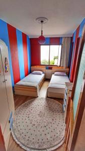 AkcaabatにあるTepedeki evのベッド2台とラグが備わる客室です。