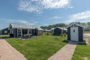 une maison avec une cour et un hangar dans l'établissement Duinpark Westerschouwen, à Burgh-Haamstede