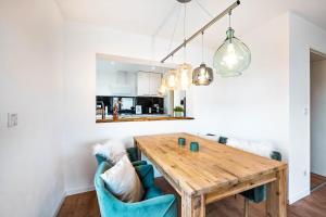 a kitchen and dining room with a wooden table and blue chairs at Casa Tortuga - Ruhige 3 Zimmer Wohnung in Hüttenfeld in Lampertheim