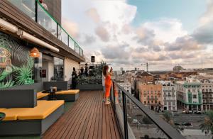 uma mulher de pé numa varanda com vista para a cidade em Sea You Hotel Port Valencia em Valência