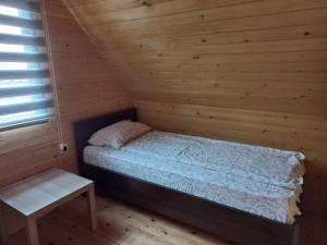 um pequeno quarto com uma cama num chalé de madeira em Brvnare Libero TARA em Sekulić 