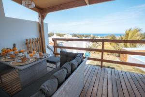 - un balcon avec un canapé et une table avec de la nourriture dans l'établissement Kaz Lucie 1, vue imprenable sur l'océan, à Saint-Pierre
