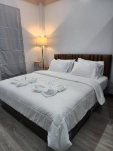 a large white bed with two napkins on it at ONE DD HOMES in Udon Thani