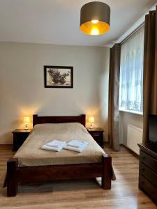 a bedroom with a bed with two towels on it at Hotelik Korona in Raszyn