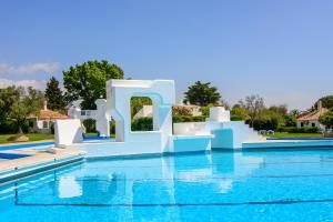 a pool at a resort with blue water at Pedras D'el Rei in Tavira