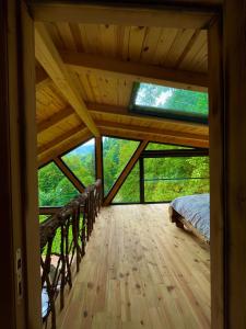 een slaapkamer in een hut met een bed op een houten vloer bij Riona dağ evleri in Çamlıhemşin