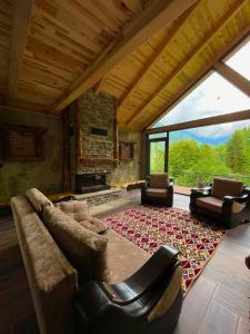 uma sala de estar com um sofá e cadeiras e uma lareira em Riona dağ evleri em Çamlıhemşin