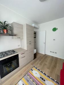 a kitchen with wooden cabinets and a stove top oven at Appartamento Miramare in Rimini +28 photos