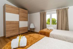 une chambre avec deux lits et une fenêtre dans l'établissement Fénix House, à Arco da Calheta