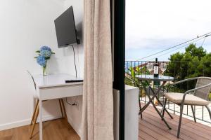 a room with a desk and a balcony with a table at Fénix House in Arco da Calheta