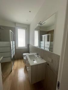 a bathroom with a sink and a toilet and a mirror at Appartamento Miramare in Rimini