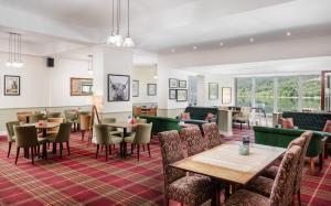a restaurant with tables and chairs and a bar at Arrochar Hotel 'A Bespoke Hotel' in Arrochar