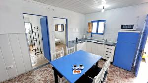 cocina con mesa azul y nevera azul en Villa Mi Olvido V.V., en Sardina