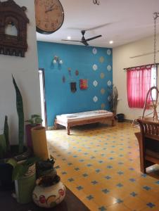 uma sala de estar com um banco numa parede azul em SHI's Shambhavi homestay -On the way to Isha, Maruthamalai em Coimbatore