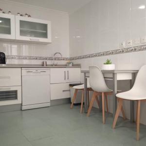 una cucina bianca con elettrodomestici bianchi e sedie bianche di Céntrico Piso, piscina y garaje a Calasparra