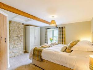 a bedroom with a large bed and a stone wall at Martin's Farm House in Richmond