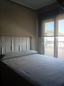 una camera con un grande letto e una finestra di Céntrico Piso, piscina y garaje a Calasparra
