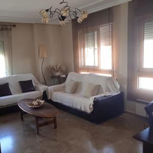 uma sala de estar com um sofá e uma mesa em Céntrico Piso, piscina y garaje em Calasparra