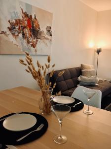 a table with plates and glasses and a couch at Wohnung im Rebenring in Braunschweig
