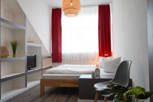 a bedroom with a bed and a window with red curtains at Aparthotel am Zwinger in Dresden +21 photos