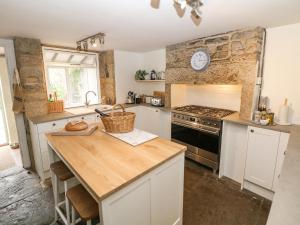 - une cuisine avec un comptoir et une cuisinière four supérieur dans l'établissement Hunters Cottage, à Bakewell