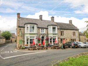 a building with tables and chairs in front of it at Hunters Cottage in Bakewell