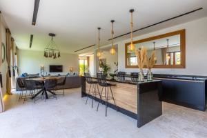 Villa Nounja Golf Amelkis Marrakech في مراكش: مطبخ وغرفة معيشة مع طاولة وكراسي