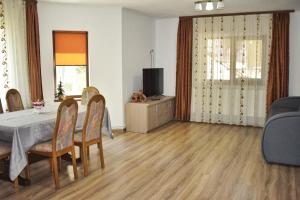 a dining room with a table and chairs and a television at Cazare Antonia in Curtea de Argeş