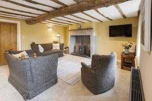 a living room with a couch and chairs and a fireplace at Joe's Cottage - Brigsteer Village near Kendal in Brigsteer