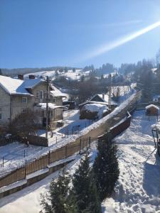 a snow covered town with houses and a bridge at Pensiunea IO-MARA in Vatra Dornei