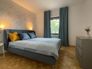 1 dormitorio con cama con sábanas azules y ventana en Garden Villa, en Štanjel