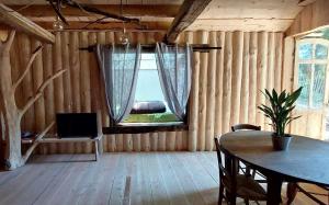 a living room with a table and a window at Cabane Salamandre in Saint-Éloy-les-Tuileries