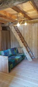 a bed in a wooden room with a wooden stairs at Cabane Salamandre in Saint-Éloy-les-Tuileries +27 photos