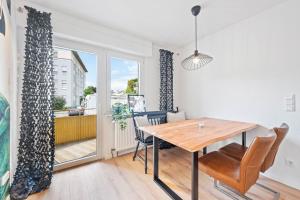 una sala da pranzo con tavolo, sedie e finestra di Casa Aguila - Ruhige, zentrale 4 Zimmerwohnung in Viernheim a Viernheim