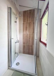 a shower with a glass door in a bathroom at Mazurek domek letniskowy do wynajęcia na mazurach in Kierwik