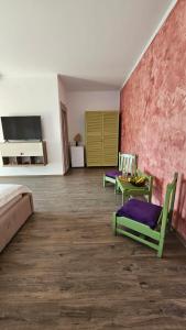 Zimmer mit einem Bett, Stühlen und einer Wand in der Unterkunft BC Aprilia in Corbu