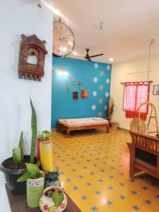 uma sala de estar com um banco e uma parede azul em SHI's Shambhavi homestay -On the way to Isha, Maruthamalai em Coimbatore