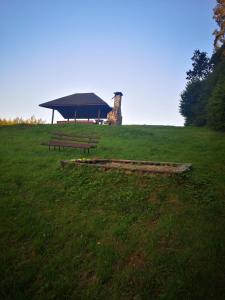 two picnic tables in a field with a building in the background at BieszczadzkaDolina in Zagórz