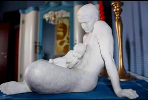 Una statua di un uomo che tiene in braccio un bambino. di B&B RESIDENZA DUCALE a Taviano