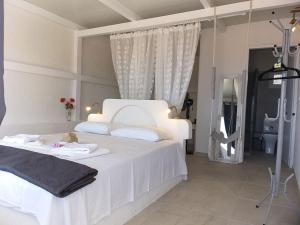 a bedroom with a white bed and a bathroom at Anatoli Studios in Skhoinoussa