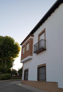 - un bâtiment blanc avec un balcon dans une rue dans l'établissement Vive el Renacimiento: Ochío, à Baeza