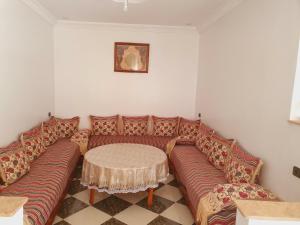 een woonkamer met een bank en een tafel bij Dar joud 2 in Chefchaouene