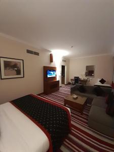 um quarto de hotel com uma cama e um sofá em Wonder Palace Hotel Qatar em Doha