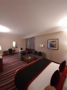 ドーハにあるWonder Palace Hotel Qatarの大きなベッドとソファが備わるホテルルームです。